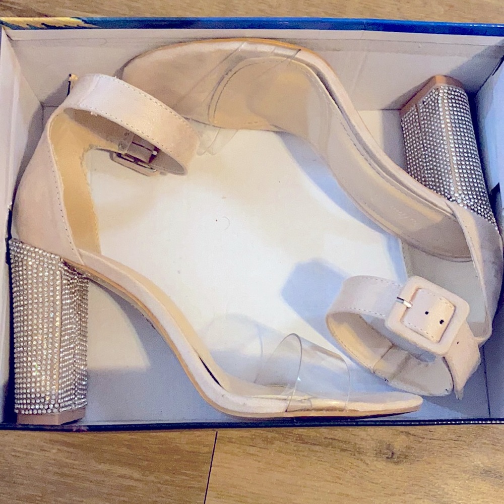 Heels with a thick diamond heel, a nudish color with a clear front strap .